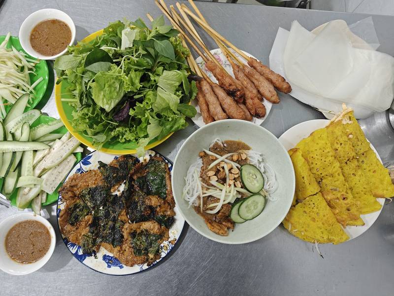 Bàn ăn đủ món: bánh xèo, nem lụi, rau sống, bánh tráng và nước chấm