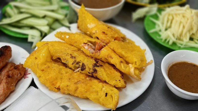 Bánh xèo vàng giòn nhân tôm bên chén nước chấm